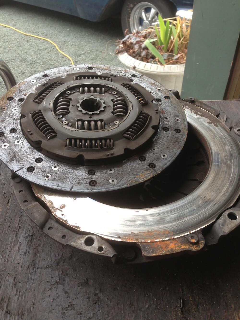 Here you can see the clutch disc and the clutch pressure plate. Both are severely worn and heavily grooved.